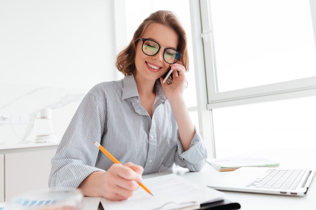 beautiful smiling woman glasses talking mobile phone while working with documents home